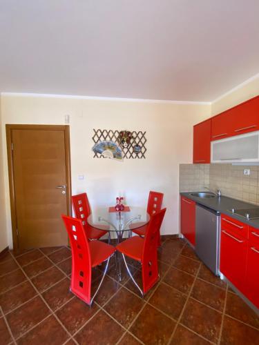 ティヴァトにあるApartments Villa Viktoriaのキッチン(赤いキャビネット、テーブル、椅子付)