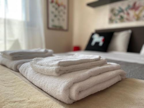 a group of white towels sitting on top of a bed at "CASA ADELIKA" Appartamento con GARAGE sulla via per il MARE in Grosseto