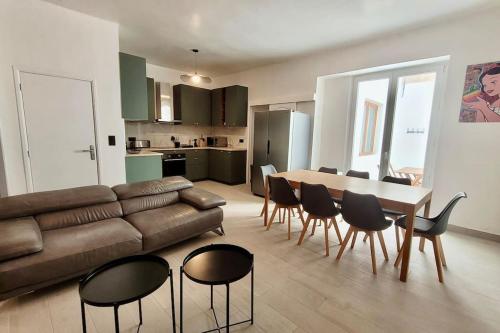un salon avec un canapé, une table et des chaises dans l'établissement Grand T5 avec patio et Sauna à 5mn à pied de la Plage des Catalans, à Marseille