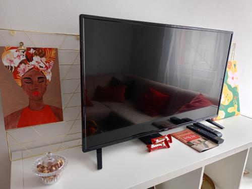 duży telewizor z płaskim ekranem siedzący na stole w obiekcie Clockwork orange apartment w mieście Vračar (historical)