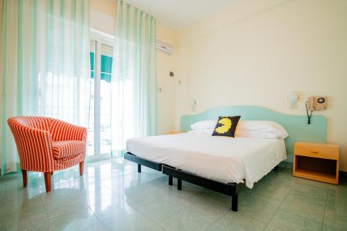 - une chambre avec un lit, une chaise et une fenêtre dans l'établissement The Match Hotel, à Cervia