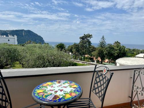 a balcony with a chair and a view of the ocean at Hotel Boutique Ideal in Ischia