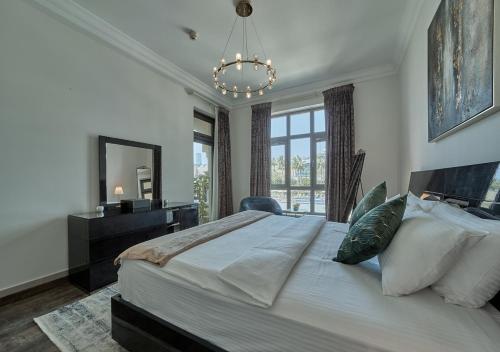 ein Schlafzimmer mit einem großen Bett mit einem Spiegel und einem Kronleuchter in der Unterkunft Burj khalifa partial view Peak living luxury 2BR Souk AL-Bahar Beside Dubai mall-GOLDEN HOMES in Dubai