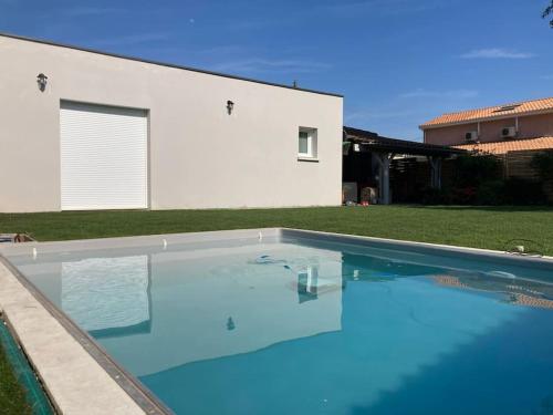 une grande piscine devant une maison dans l'établissement Pessac Pape Clément, maison avec piscine., à Pessac