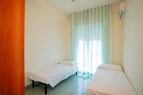 two beds in a room with a window at The Match Hotel in Cervia