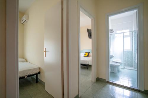 a bathroom with a toilet and a door to a room at The Match Hotel in Cervia