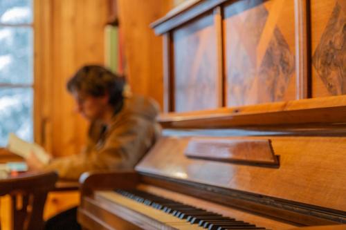 a man sitting in front of a piano at Kunst- und Naturfreundehaus Brünig in Lungern