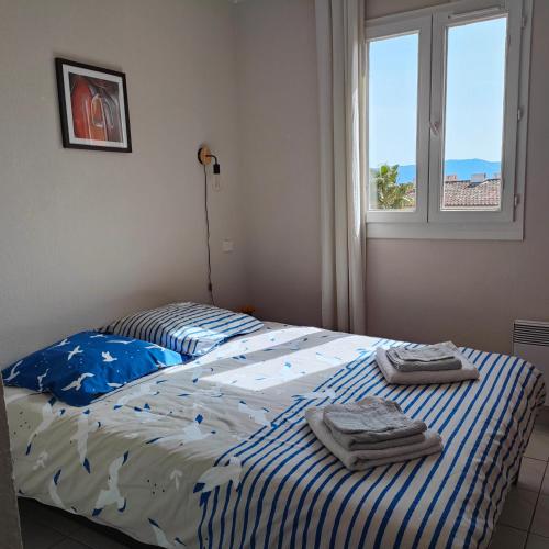 - un lit avec 2 serviettes dans une chambre dans l'établissement Taia, à Grimaud