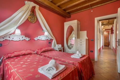 - une chambre rouge avec un lit et des serviettes dans l'établissement POMODORO di Home Hill, à Capannori