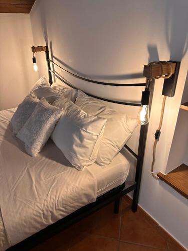 a bed with white sheets and pillows in a room at La Maisonette di Paestum - Vicino ai Templi & Wi-Fi gratuito in Paestum