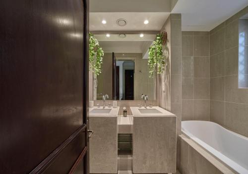 ein Badezimmer mit 2 Waschbecken und einer Badewanne in der Unterkunft Burj khalifa partial view Peak living luxury 2BR Souk AL-Bahar Beside Dubai mall-GOLDEN HOMES in Dubai
