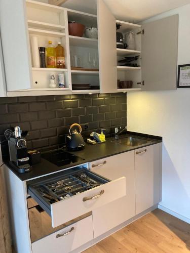 a kitchen with white cabinets and a stove top oven at Gantrisch Lodge Ottenleuebad in Guggisberg