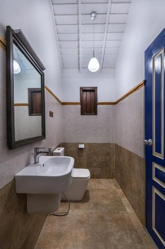 a bathroom with a sink and a toilet and a mirror at Villa Touch of Dutch in Tangalle