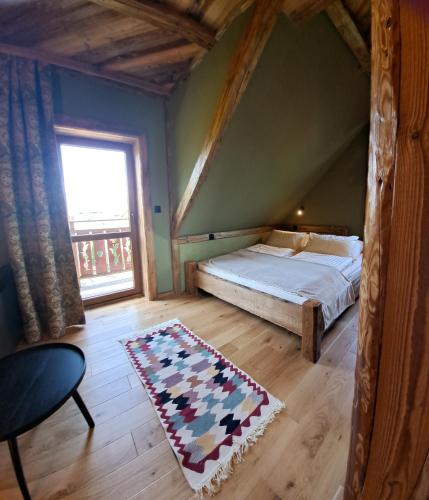 a bedroom with a bed and a large window at Domki pod sosnami in Kacwin