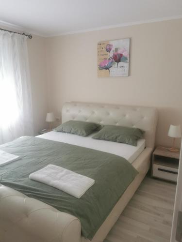 a bedroom with a large white bed with green sheets at Sidus in Satu Mare