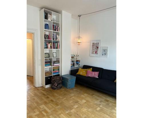哥本哈根的住宿－ApartmentInCopenhagen Apartment 43，客厅配有黑色沙发和书架