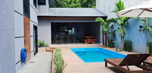a backyard with a swimming pool and a house at Sobrado com 3 Suítes, Piscina, Sala de Jogos, Garagem para 4 Carros in Florianópolis