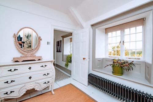 - une chambre avec une commode et un miroir dans l'établissement Magnificent Clarence cottage!, à Swanage