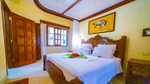 sypialnia z dużym łóżkiem z kwiatami w obiekcie Tembo Court Apartments(2 Bdrm) w mieście Malindi