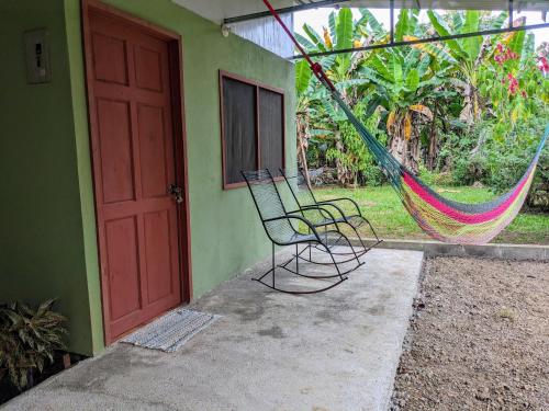 a hammock sitting outside of a house with a door at Ana Paraíso entre Arboles in Drake