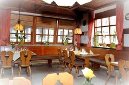 a dining room with a large wooden table and chairs at Gasthof Stern in Burgsinn