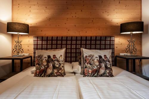 a bed with two lamps and two pillows on it at Mountainspirit in Mayrhofen