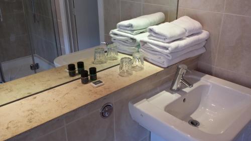 a bathroom with a sink and a mirror and towels at Remont Oxford Hotel in Oxford