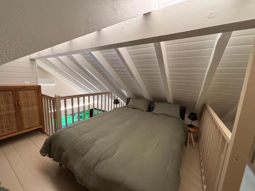 uma cama num quarto com um tecto branco em Chalet les pieds dans l'eau Lac Aiguebelette em Nances