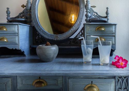 a dresser with two glasses of water and a mirror at Villa Touch of Dutch in Tangalle