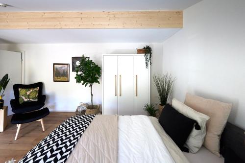 a bedroom with a bed and a chair at Gantrisch Lodge Ottenleuebad in Guggisberg
