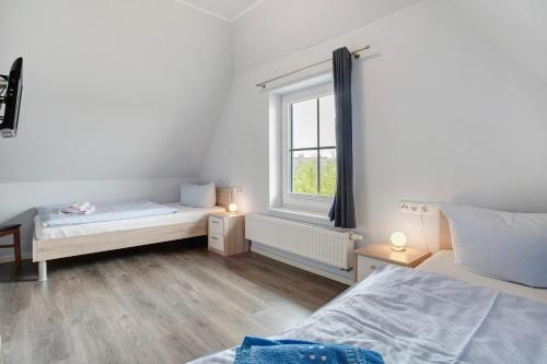 a bedroom with two beds and a window at Ferienhaus Seepferdchen in Dranske