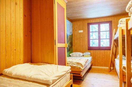 a room with two bunk beds and a window at Kunst- und Naturfreundehaus Brünig in Lungern