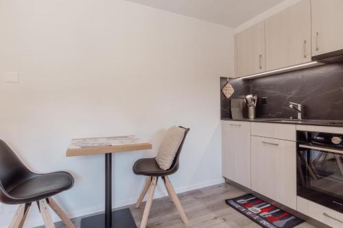 a kitchen with two stools and a table and a sink at Studio à 2 minutes des remontées mécaniques in Grimentz