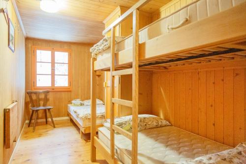 a bunk bed room with two bunk beds and a desk at Kunst- und Naturfreundehaus Brünig in Lungern