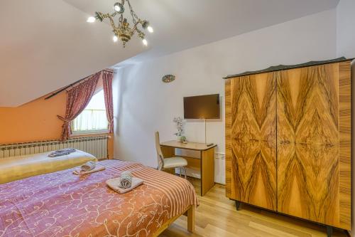 a bedroom with a bed and a desk and a table at Rooms Centar in Delnice