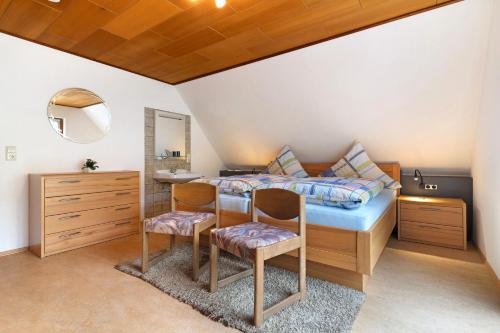 a bedroom with a bed and a desk and two chairs at Sulzerhof in Bad Rippoldsau-Schapbach