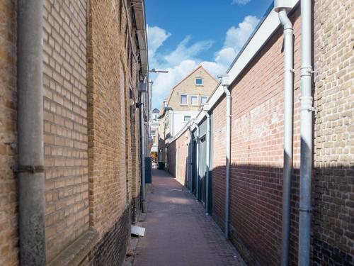 an alley between two brick buildings with a sidewalk at Modern appartement hartje Sneek in Sneek