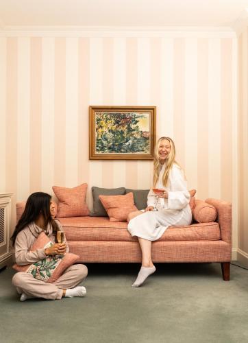 two women sitting on a couch with glasses of wine at Ballymaloe House Hotel in Ballycotton