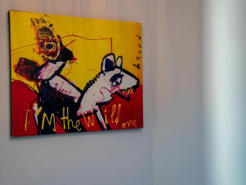 a painting of a rabbit on a yellow wall at Modern appartement hartje Sneek in Sneek