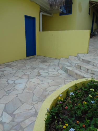 a patio with a flower bed and a blue door at Pousada B & B in Águas de Lindóia