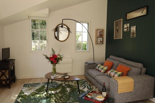 Lanvallay的住宿－la maison aux oiseaux，客厅配有沙发和桌子