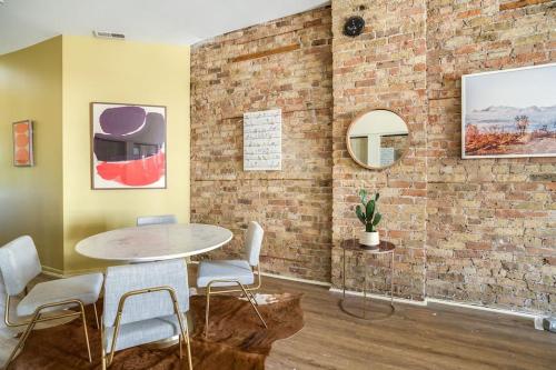 a room with a table and chairs and a brick wall at Beautifully Remodeled Third Floor Flat in River North - 3N in Chicago