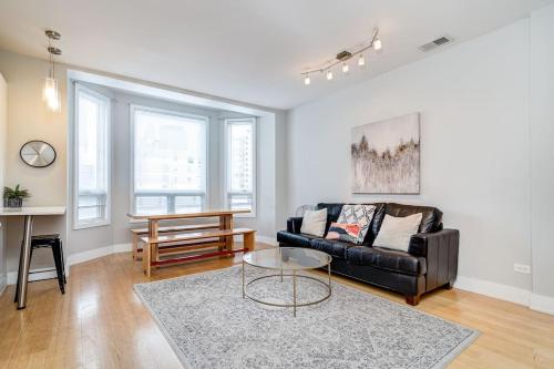 a living room with a black couch and a table at Cozy Beautiful Downtown Unit CHI in Prime River North Location near Mag Mile - 2 in Chicago