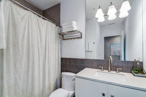 a bathroom with a toilet and a sink and a shower at Cozy Beautiful Downtown Unit CHI in Prime River North Location near Mag Mile - 2 in Chicago