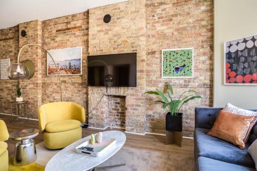 a living room with a brick wall at Beautifully Remodeled Third Floor Flat in River North - 3N in Chicago