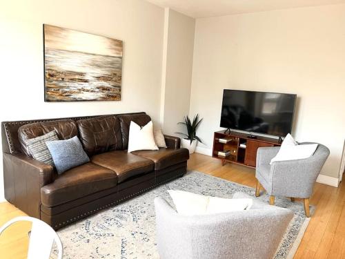 a living room with a brown couch and a television at Cozy Beautiful Downtown Unit CHI in Prime River North Location near Mag Mile - 1 in Chicago