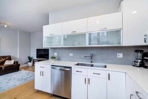 a kitchen with white cabinets and a stainless steel sink at Cozy Beautiful Downtown Unit CHI in Prime River North Location near Mag Mile - 1 in Chicago