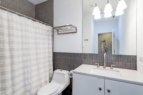 a bathroom with a toilet and a sink and a mirror at Cozy Beautiful Downtown Unit CHI in Prime River North Location near Mag Mile - 1 in Chicago