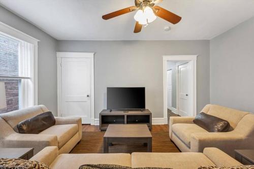a living room with two couches and a flat screen tv at Historic Second Floor Unit in Shaw Community STL 2W in Tower Grove