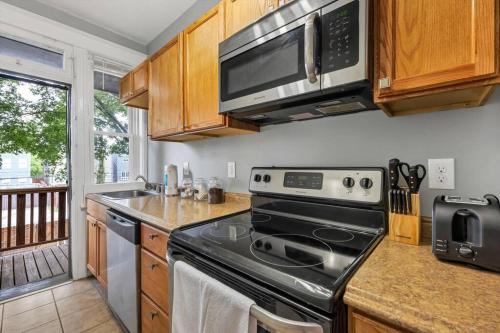 a kitchen with a stove and a microwave at Historic Second Floor Unit in Shaw Community STL 2W in Tower Grove